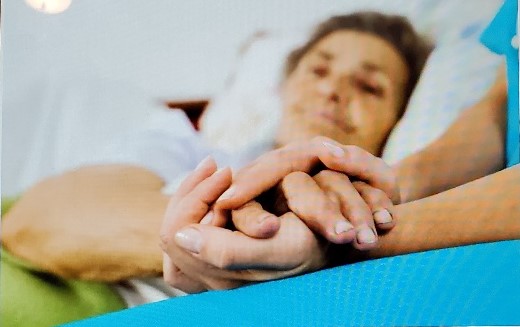 A nurse holding a patient’s hand