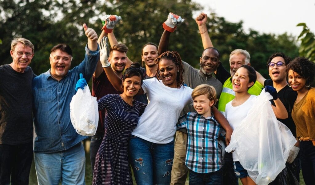 A group of people standing together with their arms raised.