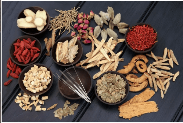 A table with bowls of various types of herbs.