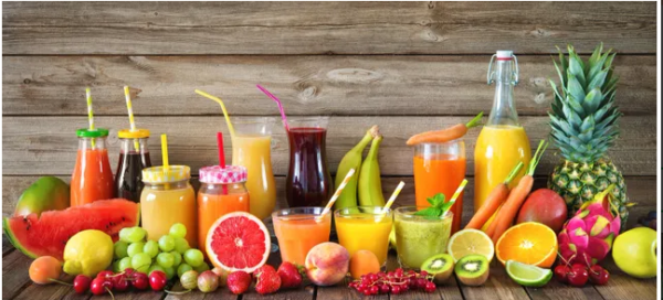 A wooden table topped with lots of fruit and drinks.