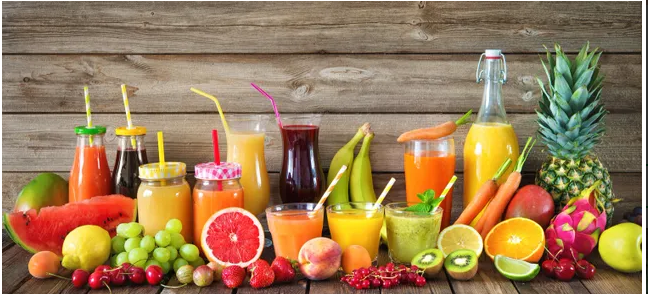 A wooden table topped with lots of fruit and drinks.